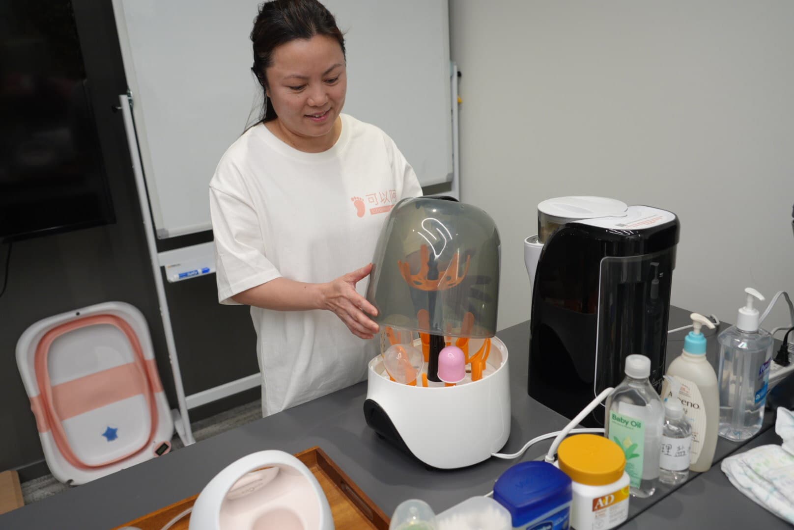 Instructor demonstrating bottle sterilizer equipment during training
