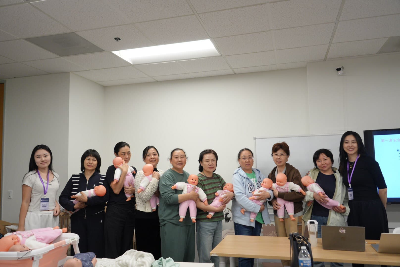 ADA training group holding baby dolls during hands-on practice session
